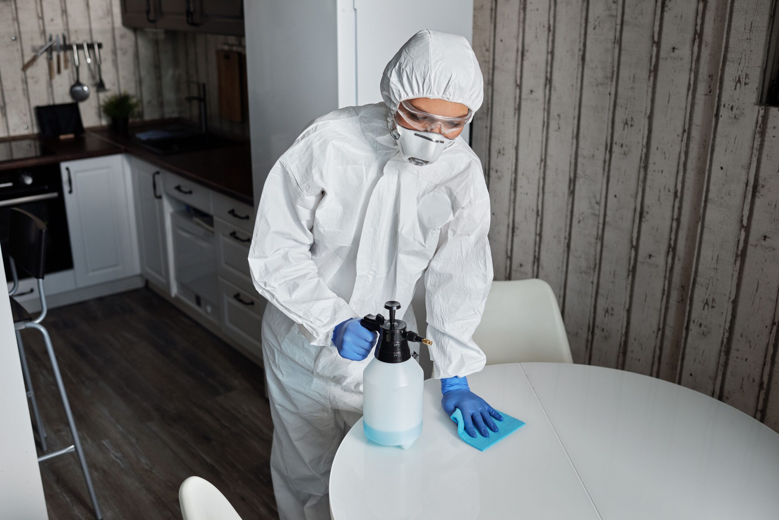 Professional technician disinfecting a commercial workspace in Harrisburg, PA using hospital-grade disinfectant and protective equipment.